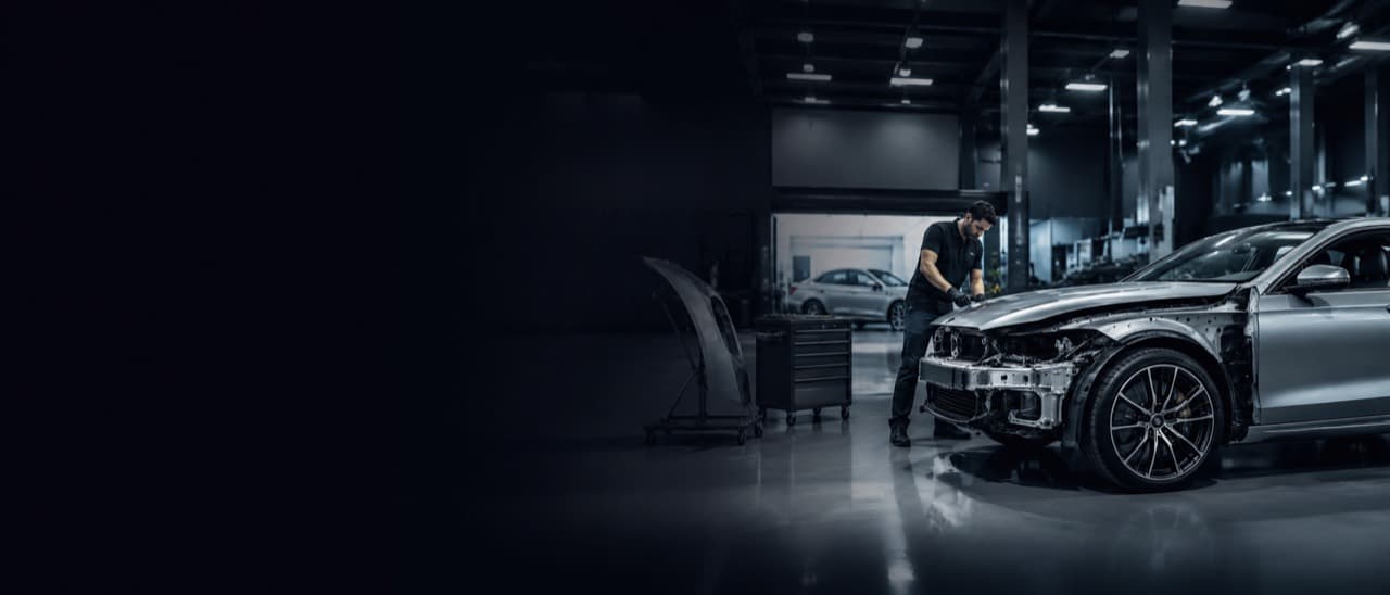 Collision repair technician working on a vehicle in a professional shop